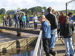Eine Besuchergruppe geht während einer Klärwerks-Führung am Rand der Becken entlang